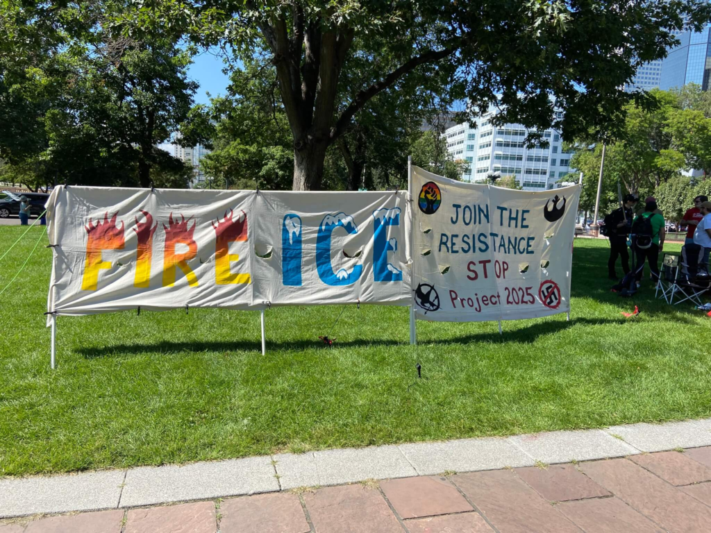 Two protest banners.  One says, "Fire ICE" and the other says, "Join the resistance stop project 2025"