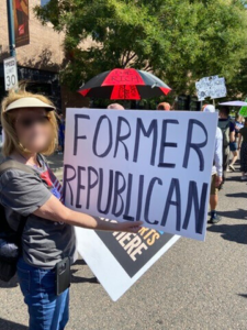 Person holding a protest sign that says, "Former Republican"