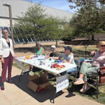Voter registration table with volunteers sitting outside ready to talk to students