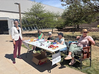 Voter registration table with volunteers sitting outside ready to talk to students